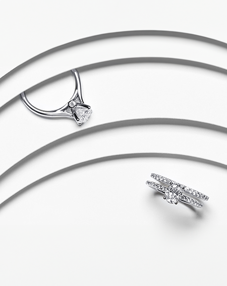 A Birks Ros&eacute;e du Matin infinity solitaire and Birks 1879 solitaire diamond engagement rings on a white background.